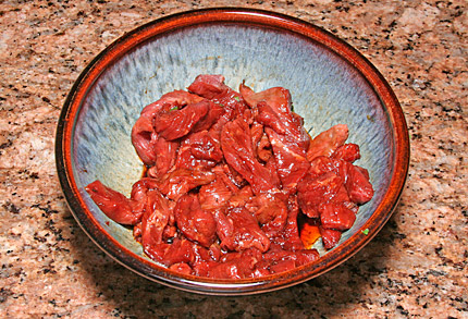 The raw beef marinating for a few minutes in soy sauce and hot oil.