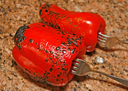 Roasting peppers over a gas burner on stove.