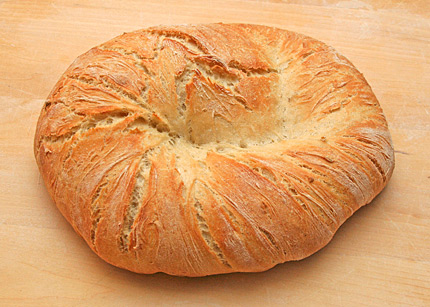 A loaf of roasted garlic bread in a twisted pattern.